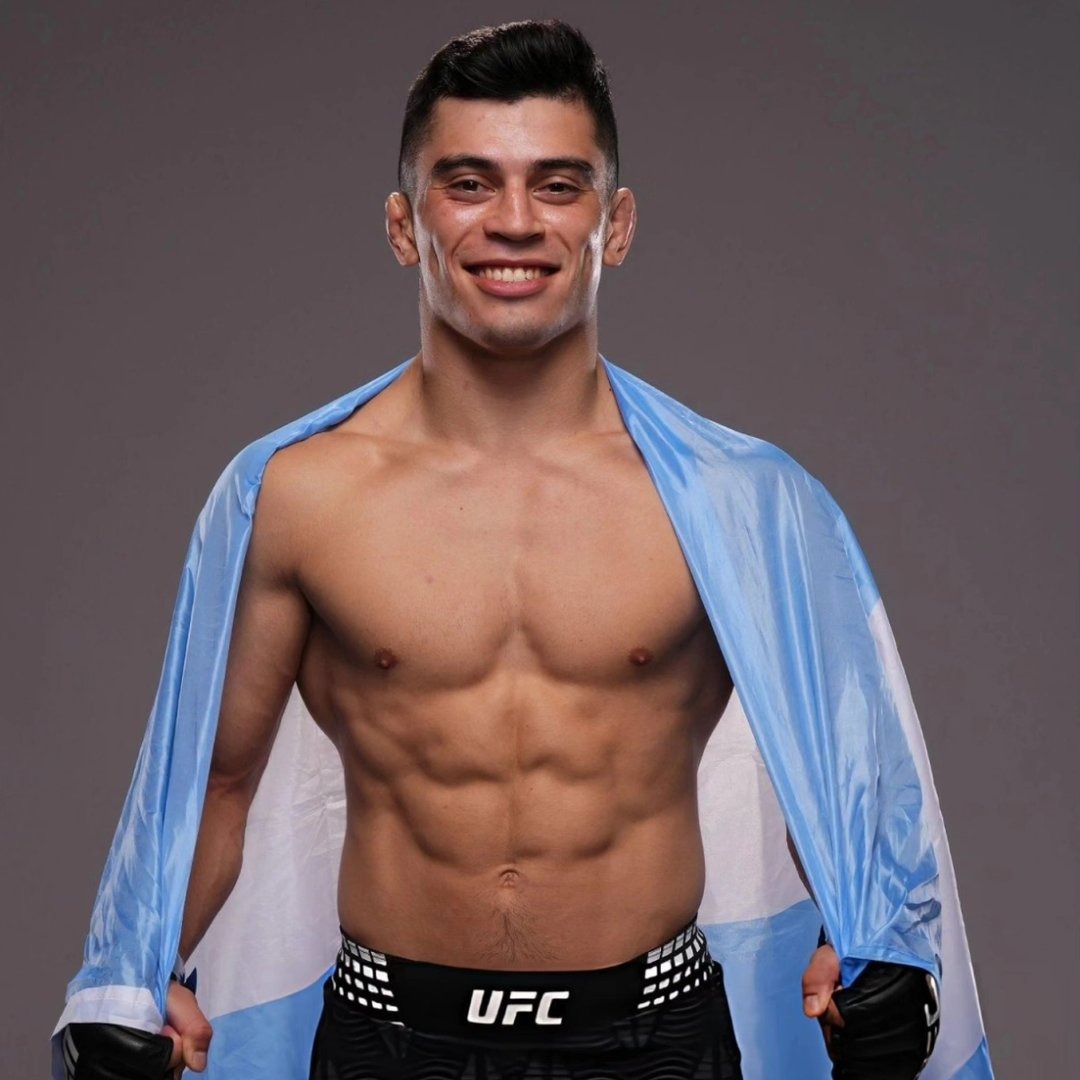 Chino Vallejos sonriendo con la bandera argentina sobre los hombros