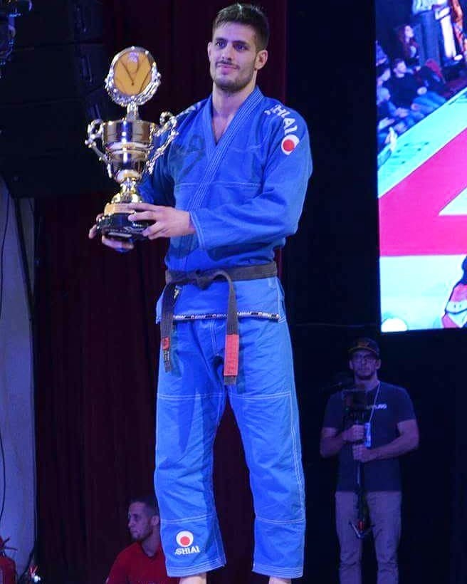 Franco Marini sosteniendo un trofeo sobre el escenario de una competencia